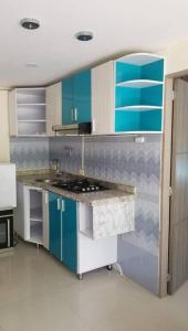 uma cozinha com armários azuis e brancos e um balcão em Precioso apto con un aire acondicionado en la Sala em Ricaurte
