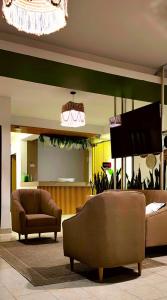 sala de estar con sofá y TV de pantalla plana en HOTEL BOHO BOUTIQUE en Quibdó