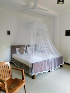 um quarto com uma cama e uma rede mosquiteira em Leen Tangalle em Tangalle