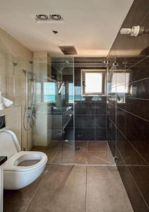 e bagno con servizi igienici e doccia in vetro. di הקומה ה 16 POOL PENTHAUSE a Hadera