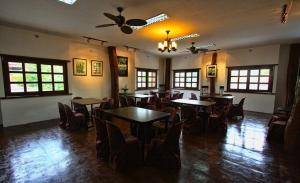 a dining room with tables and chairs and windows at Travelbee Heritage Inn in Dapitan