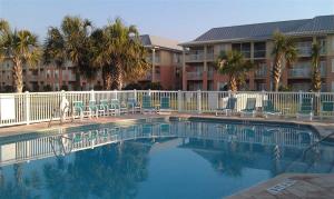 a large swimming pool with chairs and a building at Seaside at Anastasia 306 in Saint Augustine Beach