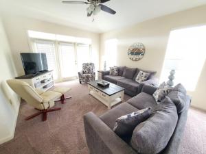 a living room with a couch and a tv at Seaside at Anastasia 306 in Saint Augustine Beach