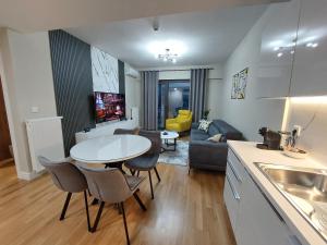 eine Küche und ein Wohnzimmer mit einem weißen Tisch und Stühlen in der Unterkunft Divine 69 Luxury Apartment, Skopje City - Center, Diamond Residences, free parking in Skopje
