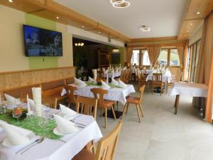 a dining room with white tables and chairs at Gasthof Trattner Pension Waldhof in Sankt Peter am Kammersberg