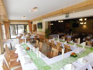 a dining room with white tables and chairs at Gasthof Trattner Pension Waldhof in Sankt Peter am Kammersberg