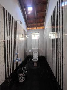 a bathroom with a toilet and a window at Revibe Beach Hostel Gokarna in Gokarna