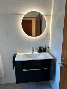 a bathroom with a sink and a mirror at Apartment - Über den Wolken in Batschuns