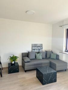 uma sala de estar com um sofá cinzento e uma mesa em Apartment - Über den Wolken em Batschuns