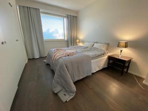 a bedroom with a large bed and a window at Style 1BR Appartment in Kemi - Tornio in Kemi