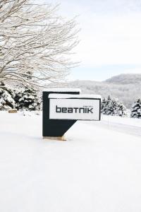 un panneau indiquant une lixe assise dans la neige dans l'établissement Beatnik Hotel, à Bromont