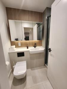 a bathroom with a toilet and a sink and a mirror at Stunning 2-Bed Apartment in Brentford in Brentford