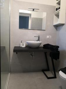 ein Bad mit einem Waschbecken und einem Spiegel in der Unterkunft Villa Maria in Dorgali