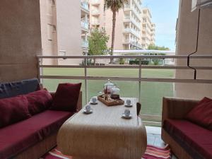 a room with a table and two couches and a window at Playa Cannet del Berenguer 7 pers piscina tennis in Canet de Berenguer