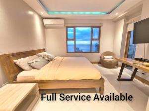 a bedroom with a bed and a desk and a television at Manila BayView Rental- Luxury 1,2,3,4 BR Condos with BALCONY POOL BAYVIEW - FULL SERVICE AVAILABLE in Manila