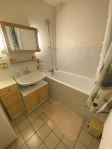 a bathroom with a sink and a tub and a toilet at Les chênes Rouges 4/p in Gérardmer