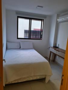 um quarto com uma cama, uma janela e uma secretária em Apto Novo PraiaTambaúCabo Branco em João Pessoa