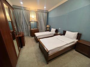 a hotel room with two beds and a television at Swan Hotel Baku in Baku