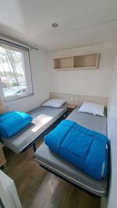 Habitación pequeña con 2 camas y ventana en 490 Emplacement luxe aux Dunes de Contis 3*, en Saint-Julien-en-Born