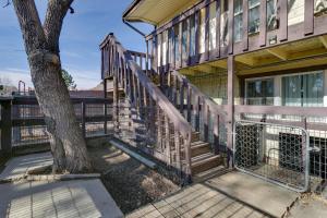 a house with a staircase next to a tree at Convenient Colorado Horse Farm Apt with Balcony! in Aurora