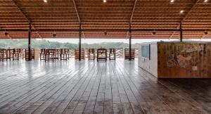 a large room with wooden tables and chairs in it at Leo Woods Hampi River view in Hampi