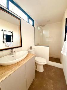 a bathroom with a sink and a toilet and a mirror at La Casa del Colibri in Concepción