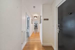 a hallway with white walls and a black door at Great 2 Bed Flat With City View in London