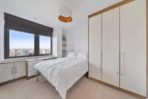 a bedroom with a large bed and a window at Great 2 Bed Flat With City View in London