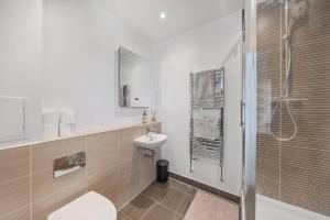 a bathroom with a sink and a toilet and a shower at Great 2 Bed Flat With City View in London