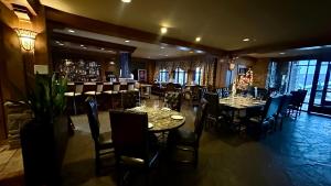 restauracja ze stołami i krzesłami oraz bar w obiekcie Ski on Ski off Mtn Chalet w mieście Vernon