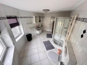 uma casa de banho branca com um chuveiro e um WC. em Villa Hardegsen em Hardegsen
