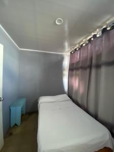een kleine kamer met een bed en een tafel bij Hotel Rio Puntarenas in Puntarenas