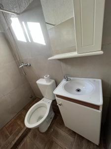 une salle de bain avec des toilettes blanches et un lavabo dans l'établissement Casita sencilla a cuatro cuadras del mar, à La Aguada