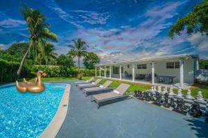 einen Pool mit Liegen und einen Pool-Noodleinger in in der Unterkunft New Tropical Oasis Retreat in Miami in Miami