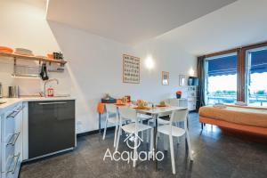 Acquario Suites في جينوا: مطبخ وغرفة معيشة مع طاولة وكراسي