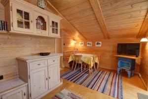 a dining room with a table and a tv in a cabin at Ferienwohnung Birkenmeier in Ruhpolding