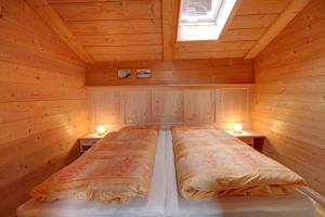 a bedroom with two beds in a wooden cabin at Ferienwohnung Birkenmeier in Ruhpolding