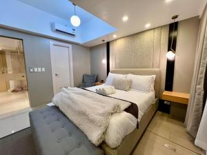 a bedroom with a large bed and a bathroom at Hotel Vibe Condo at Uptown Parksuites BGC in Manila