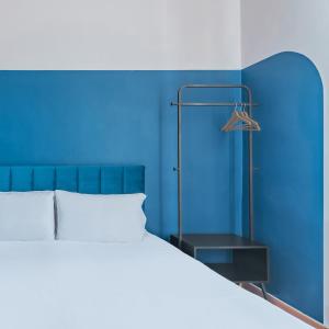 Dormitorio azul con cama y pared azul en Hotel Infinito - Gruppo BLAM HOTELS, en Roma