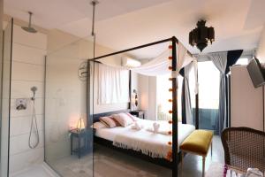 een slaapkamer met een hemelbed en een douche bij Les Suites in Santa María de Palautordera
