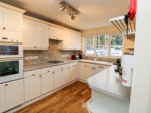 uma cozinha com armários brancos e um forno com placa de fogão em Mountbatten House em Plymouth