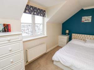 - une chambre avec un lit blanc et un mur bleu dans l'établissement Mountbatten House, à Plymouth