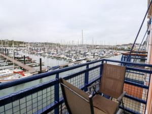 uma varanda com uma cadeira e uma marina com barcos em Mountbatten House em Plymouth