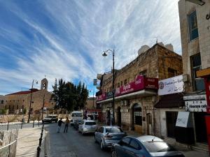 a city street with cars parked on the street at Downtown Inn Madaba in Madaba