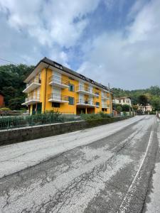 a yellow apartment building on the side of a road at La Garçonniérre del Lago Maggiore in Nebbiuno