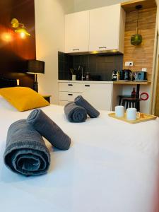a bedroom with a bed with towels on it at Appart'Hôtel La Parisienne in Montreuil +3 photos