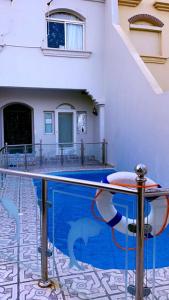 una piscina di fronte a un edificio con una casa di فيلا على البحر درة العروس a Durat Alarous