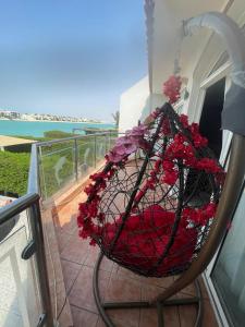 una cesta llena de flores rojas en el balcón en فيلا على البحر درة العروس, en Durat Alarous