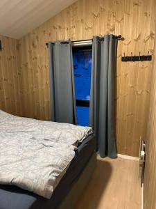 1 dormitorio con cama y ventana en Malangen Arctic Sealodge Cabin 10, en Meistervik
