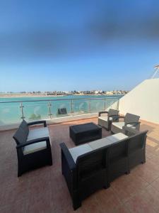een patio met banken en tafels op een dak bij فيلا على البحر درة العروس in Durat Alarous